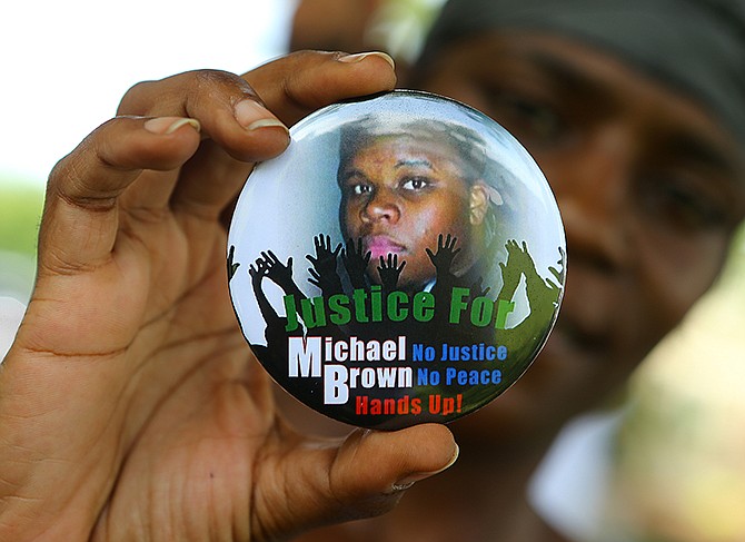 In this Aug. 21 photo, Nikki Jones, of Spanish Lake, holds a button in support of Michael Brown while visiting the community in the apartment development near where he was fatally shot in Ferguson. After Brown's Aug. 9 shooting death at the hands of a white police officer, his legacy continues to evolve. 