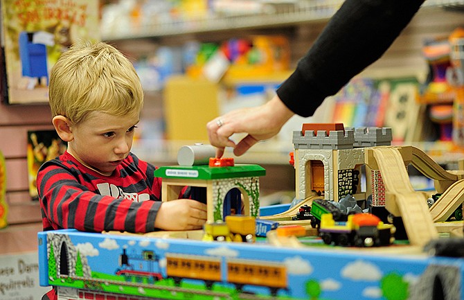 Ben Godsy, 3, gets a helping hand from his mom Misty Godsy while pushing a Thomas the Train car through the wash station as the two take a little time to play while shopping at Downtown Book and Toy in Jefferson City.