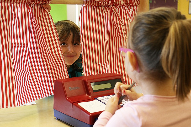 Raegen Cole surprises Aubree Dille after pulling the curtain back on a play kitchen set at Fulton Education Center's new preschool Monday afternoon. FEC's new preschool, for children at least four years of age, has 20 students enrolled. They have space for up to 30 students total.