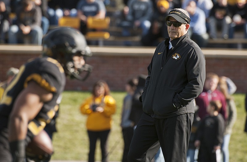 Missouri head coach Gary Pinkel watches over the Tigers as they warm up before Friday's game against Arkansas in Columbia.