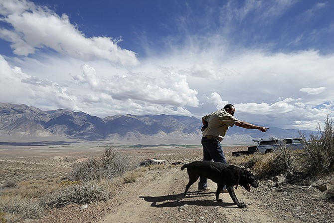 Paul Dostie points as his dog Buster sets off to search an area near Bishop, California. For years, Buster and Dostie have worked together to unlock mysteries, to find the bodies of fighting men who fell long ago on foreign battlefields, or of victims of unsolved crimes or disappearances. In all, Dostie said Buster has helped find the remains of about 200 people.