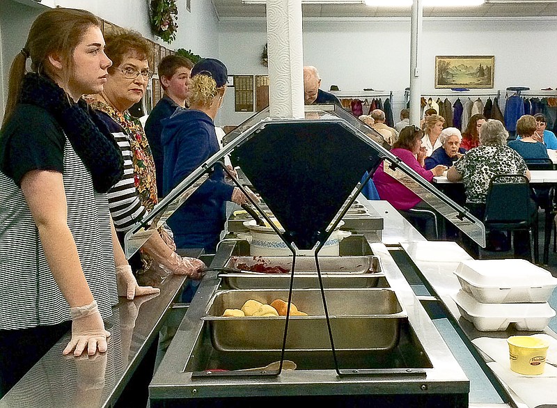 Natalie Rosslan and Dawn Cook are among the volunteers serving meals at the annual California Ministerial Alliance at the California Nutrition Center on Thanksgiving Day.