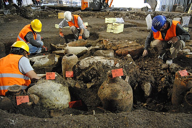 Archeologists work next to unearthed amphoras in Rome. Archaeologists have unearthed an ancient commercial farm in the heart of modern Rome, taking advantage of subway construction to explore unusually deep for urban settings. They explored some 60 feet down near St. John in Lateran Basilica.