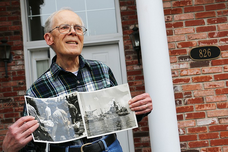 Richard White poses at his Fulton home holding two photos that show the ship he served on after it was struck by a torpedo. They lost 20 people that day. 