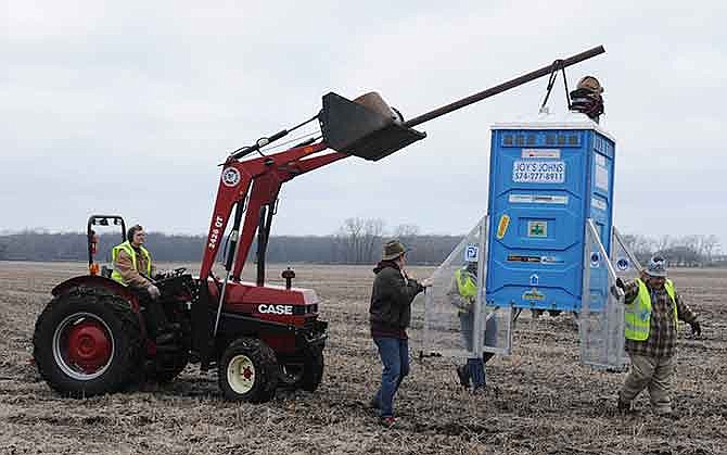 Members of the Michiana Rocketry prep a 10-foot, 450 pound porta-potty, mounted on rocket motors for launching, Saturday, Dec. 6, 2014, from a field in Three Oaks, Mich.