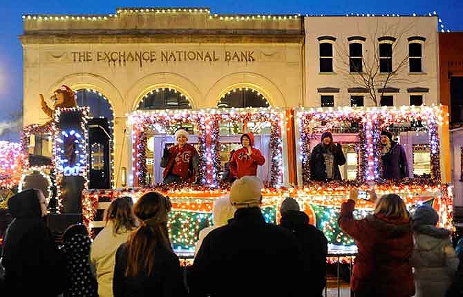 Crowds cheer and wave as the Calvary Lutheran High School float travels down High Street on Saturday as part of the 75th annual Jefferson City Jaycees Christmas Parade.