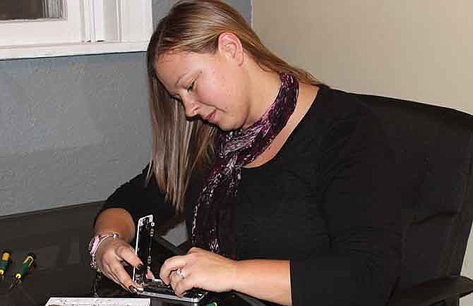 Tracie Kerley replaces an iPhone screen at Tech-Know, 322 Jefferson St. The new technology shop in Jefferson City offers repairs for smartphones and tablets. 