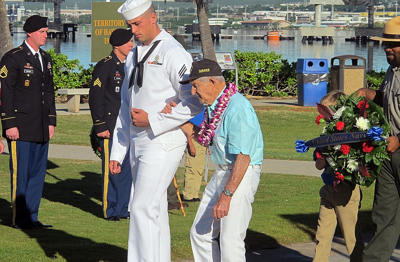 A Navy sailor escorts Navy veteran and Pearl Harbor survivor John Chapman during a ceremony to mark the 73rd anniversary of the Japanese attack on Pearl Harbor. The attack launched the U.S. into World War II.