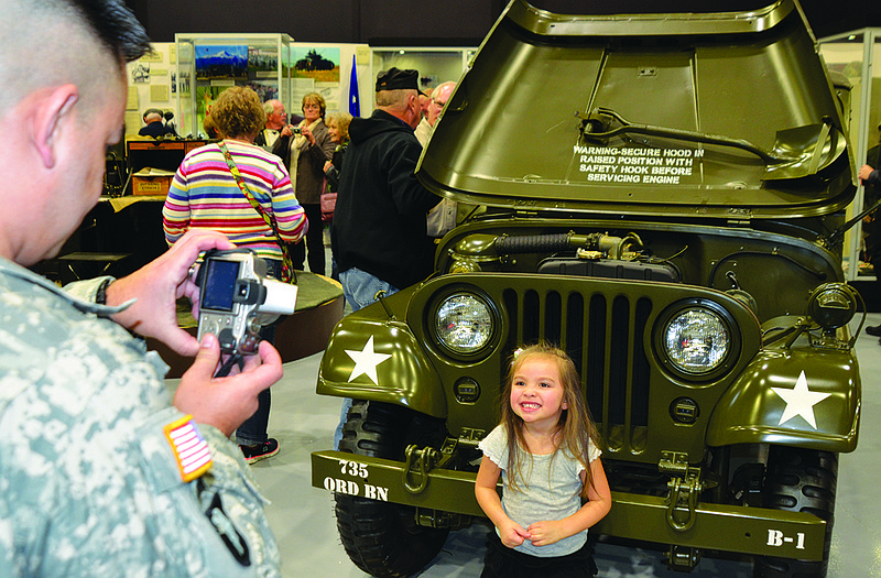 Ty Stafford, who works in public affairs with the Missouri National Guard, takes a picture of daughter Isabella, 3, at Sunday's grand opening of the new Museum of Missouri Military History at the Ike Skelton Training Site.