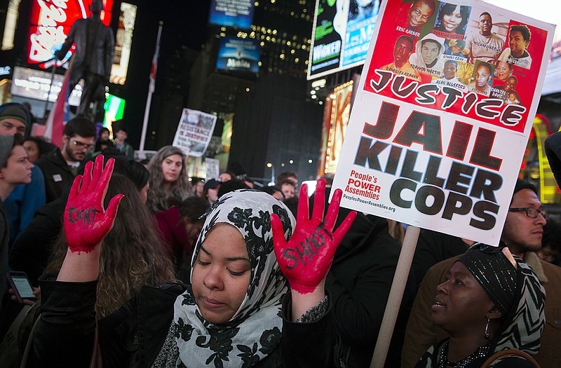 In this Nov. 25 photo, demonstrator Maryam Said raises her painted hands during a protest against a grand jury's decision on Monday not to indict Ferguson police officer Darren Wilson in the shooting of Michael Brown in New York. No firm statistics can say whether a spate of officer-involved deaths is a growing trend or simply a series of coincidences generating a deafening buzz in news reports and social media.