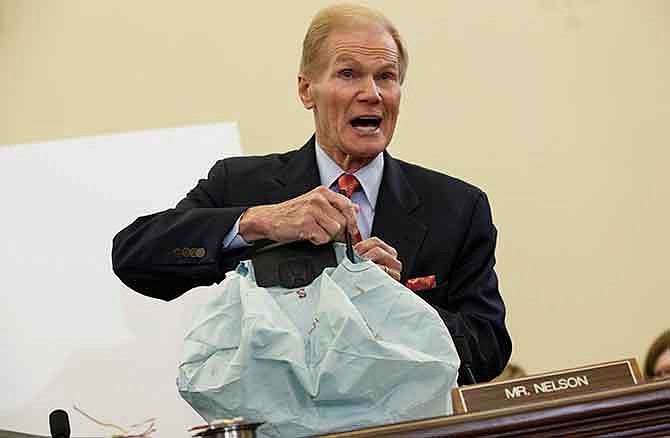 In this Nov. 20, 2014 file photo, Senate Commerce Committee member Sen. Bill Nelson, D-Fla. displays the parts and function of a defective airbag made by Takata of Japan that has been linked to multiple deaths and injuries in cars driven in the US, during the committee's hearing on Capitol Hill in Washington. Japan's Takata Corp. refused to comply with a U.S. government demand for an expanded recall of its air bags that can explode and shoot out shrapnel, and instead passed along the crucial decision to automakers. 