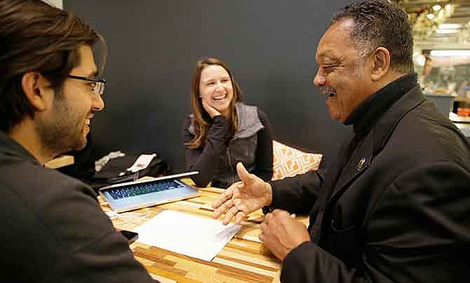 In this photo taken Monday, Dec. 8, 2014, Rev. Jesse Jackson, right, visits Kacie Gonzalez, vice president of business development, center, and Nick Norena, both with the company Shoto, at the Workshop Cafe in San Francisco. Now that Jackson and, his group, Rainbow Push, have gotten the technology industry's biggest companies to confront an embarrassing shortage of women, African-Americans and Hispanics on their payrolls, he is stepping up the pressure to come up with solutions at workshop to be held Wednesday in Silicon Valley.