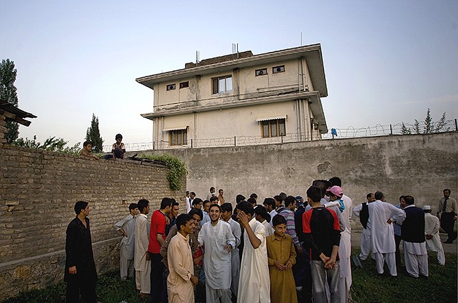 In this May 2011 photo, local residents gather outside a house, where al-Qaida leader Osama bin Laden was caught and killed in Abbottabad, Pakistan. After U.S. Navy SEALs killed Osama bin laden in Pakistan in May 2011, top CIA officials secretly told lawmakers that information gleaned from brutal interrogations played a key role in what was one of the spy agency's greatest successes. 