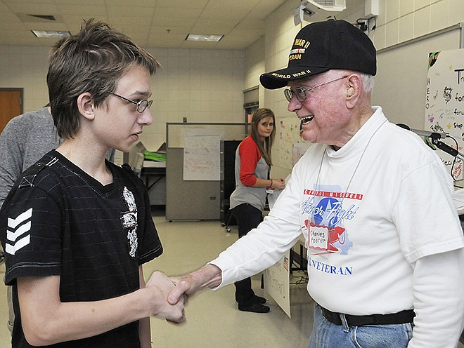 Ethan Kirk shakes hands with Charles Foster, right, after Foster's presentation about his Honor Flight trip and his question and answer segment about his service in World War II. Students at Lewis and Clark made donations to the Honor Flight so Foster wanted to thank them by telling his experiences on the flight and visit to the WWII Memorial in Washington.
