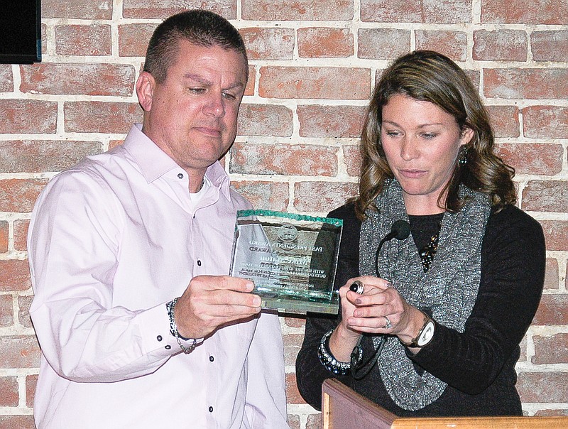 Outgoing CPI President Mike Staton, left, is presented an award for his service by CPI Vice president Becky Lawson. The presentation was made at the annual Christmas dinner