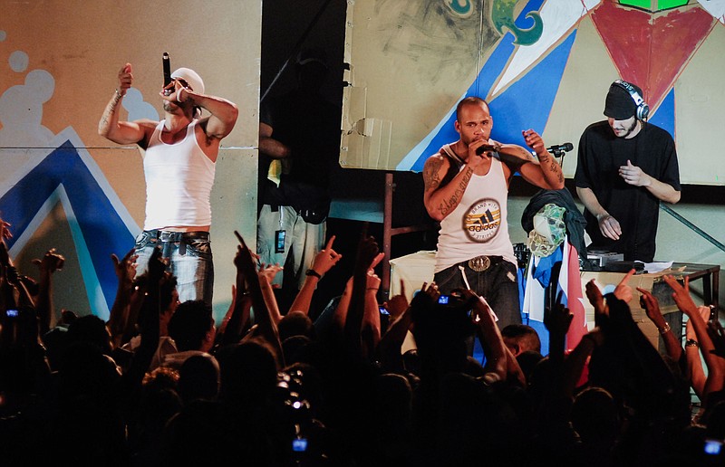 In this April 23, 2010 photo, members of Los Aldeanos, Aldo Rodriguez, left, and Bian Rodriguez, center, perform in concert at the Acapulco Theater in Havana, Cuba. Documents obtained by The Associated Press show that a U.S. agency infiltrated Cuba's hip-hop scene, recruiting unwitting rappers to spark a youth movement against the government.