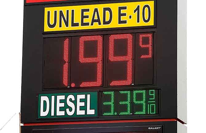 In this Dec. 3, 2014 file photo a sign displays the price for E-10 gasoline for $1.99 at the OnCue convenience store and gas station in Oklahoma City. With oil prices now around a five-year low, budget officials in about a half-dozen states already have begun paring back projections for a continued gusher of revenues and more could be necessary if oil prices stay at lower levels.