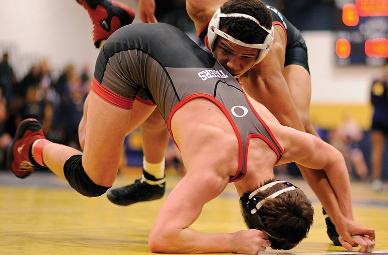 Jefferson City's Christian Mayberry drives Ozark's Levi Castleberry to the mat in their 132-pound matchup in the first round of Friday's Missouri Duals at Helias.