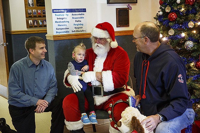 Santa meets with Special Learning Center student Charlotte Bickel, 2, Wednesday at the school. Along with Santa, Cosmopolitan Club members Brian Mutert, left, and Tom Henke handed out toys and presented a check to the Special Learning Center for $47,500 from the Tom Henke Charity Classic golf tournament. The charity golf game has raised more than $1 million for the school. 