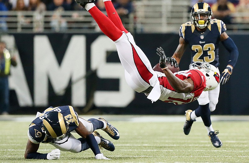 Rams cornerback upends Cardinals wide receiver Jaron Brown in the first quarter of last Thursday night's game at the Edward Jones Dome.