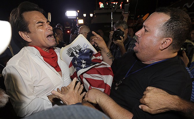 Anti-Castro protester Sisay Barcia, right, argues with pro-Obama supporter Peter Bell, left, in the Little Havana area of Miami, Wednesday. Barcia expresses his disagreement with a surprise move announced by senior Obama administration officials that could pave the way for a major shift in U.S. policy toward Cuba. 