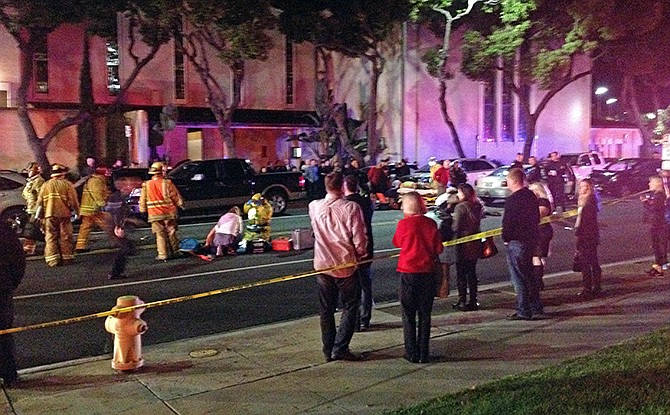 In this photo, firefighters work on a victim at left after a driver suspected of being intoxicated hit a group of pedestrians and another car outside a church as a Christmas service ended in the Los Angeles suburb of Redondo Beach, California Wednesday evening. Three people were killed and several others were injured including five children, police said.