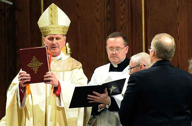 In this Wednesday, Dec. 17, 2014 photo, Bishop James Johnston leads a service for the dedication of the new St. Mary's Catholic Church in Joplin, Mo. at the church. Members of the Joplin parish whose church, rectory and elementary school were destroyed in the May 2011 tornado have celebrated the first Mass at their new building. Hundreds of residents packed the new St. Mary's Catholic Church on Wednesday for a dedication service and its first Mass, The Joplin Globe reported.