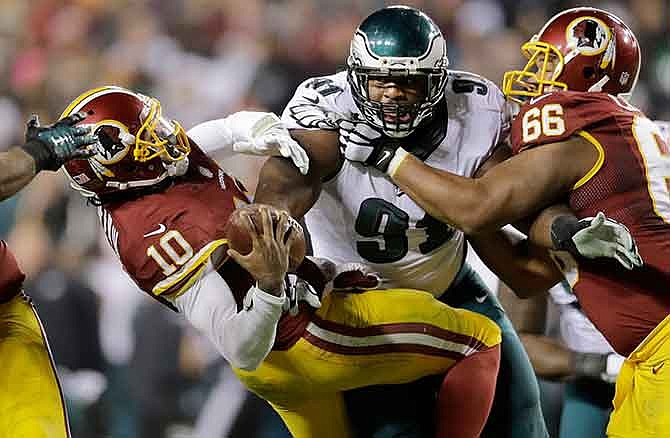 Washington Redskins quarterback Robert Griffin III (10) is sacked by Philadelphia Eagles defensive end Fletcher Cox (91) during the second half of an NFL football game in Landover, Md., Saturday, Dec. 20, 2014.