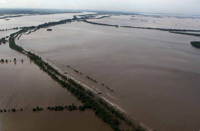  In this May 3, 2011 file photo white caps from flood waters pouring onto Missouri farmland outline the Birds Point levee on the Mississippi River after it was intentionally blown up to reduce the river level just enough to spare nearby Cairo, Ill., a town where 72 percent of the 2,600 residents are black. Government and civic leaders say a new levee project in the Missouri Bootheel region, part of the same levee system, would increase the flood risk in predominantly black communities in Illinois.