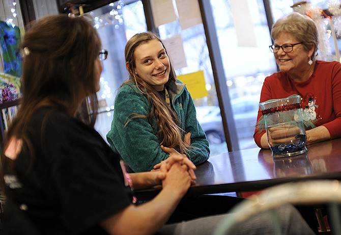 Corrin Lepper, center, smiles while talking with her Big Brothers/Big Sisters "big," Bev Price, right, and her mother Marianna Coussas, left, during a recent visit to YoYums.