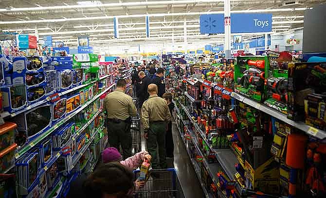 Members of area law enforcement agencies scan the toy aisles for the perfect items with young shoppers Saturday morning during the Operation: T.O.Y.S. event at Walmart in eastern Jefferson City.
