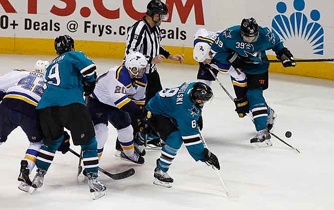 St. Louis Blues' Jay Bouwmeester, second from right, and San Jose Sharks' Logan Couture, right, struggle for the puck during the second period of an NHL hockey game, Saturday, Dec. 20, 2014, in San Jose, Calif.