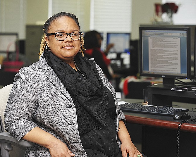 La'Tosha Nesbit sits at her work desk at Rose International. Nesbit noted the clothing she was wearing was provided by Dreams to Reality.