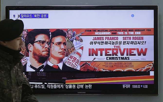 A South Korean army soldier walks near a TV screen showing an advertisement of Sony Picture's "The Interview," at the Seoul Railway Station in Seoul, South Korea on Monday. North Korea hates the Hollywood film that revolves around the assassination of its beloved leader, but the country has had a long love affair with cinema - of its own particular styling. 