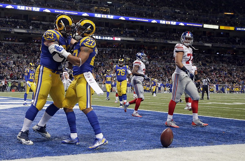 Rams center Scott Wells congratulates running back Tre Mason after Mason's 10-yard touchdown run in the first half of Sunday's game against the Giants in St. Louis.