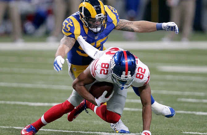 New York Giants wide receiver Rueben Randle, bottom, is stopped by St. Louis Rams linebacker James Laurinaitis after catching a pass for a 10-yard gain during the second half of NFL football game Sunday, Dec. 21, 2014, in St. Louis.