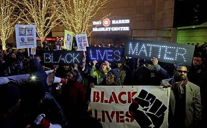 Protesters yell outside the Bradley Center before an NBA basketball game between the Milwaukee Bucks and the Charlotte Hornets Tuesday, Dec. 23, 2014, in Milwaukee. The group is protesting Monday's announcement that no charges against former police office Christopher Manney were filed in the fatal shooting of Dontre Hamilton.