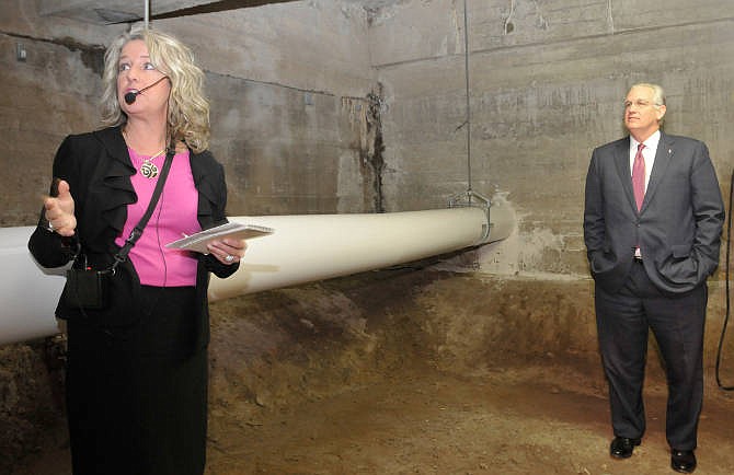 Gov. Jay Nixon, at right, tours the basement and sub-basement of the Capitol, Monday, Dec. 15, 2014, in Jefferson City, Mo. At left, Cathy Brown, Director of Facilities Management, leads the tour through the dirt and, in areas, mud floors that make up the sub-basement for the building's foundation. Years of water seepage have caused a number of issues including, mold, stalactites and cracks in foundation among other problems. Nixon has decided to use some of the money set aside for Capitol repairs to pay for a one-percent increase in state employee wages and enhanced tourism promotion efforts.