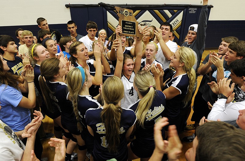Blake Berhorst hoists the Class 3 District 12 championship trophy while surrounded by her Lady Crusaders teammates and members of the Helias student section following their tournament title win  earlier this year at Rackers Fieldhouse. Helias went on to capture the Class 3 state championship to wrap up an undefeated season.