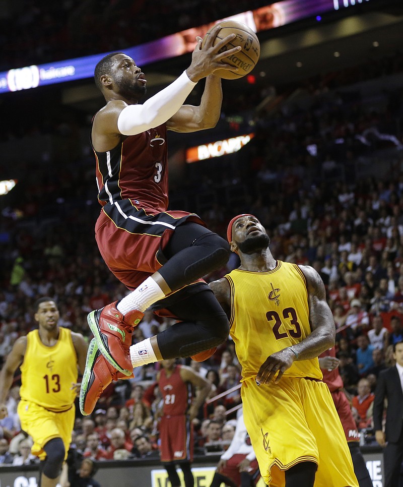 Dwyane Wade of the Heat goes up for a shot in front of LeBron James of the Cavaliers during Thursday's game in Miami.