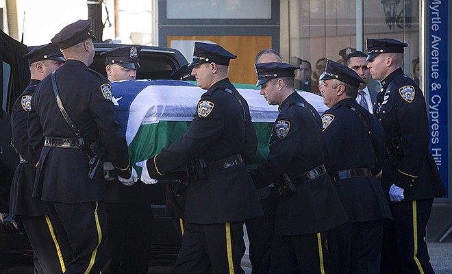 New York City police officers carry the casket of New York Police Department officer Rafael Ramos at his wake at Christ Tabernacle Church, in the Glendale section of Queens, Friday, in New York.  Ramos was killed Dec. 20 along with his partner, Officer Wenjian Liu, as they sat in their patrol car in Brooklyn.