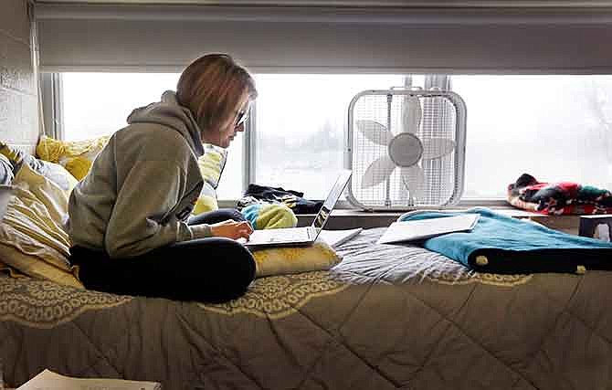 In this Dec. 9, 2014 photo, Adrian College student Abby Slusher studies in her dorm in Adrian, Mich. The small, private Michigan college has got a deal for you: Make at least $37,000 a year after graduating or else the school will pay all or part of your loan. Adrian College has taken out an insurance policy costing about $1,100 on each student starting with this year's freshmen. The idea is to eventually help graduates who might want to go into fields like social work, and also ease incoming students' "sticker shock" when they see the $40,000 annual cost of the education before financial aid is factored in.