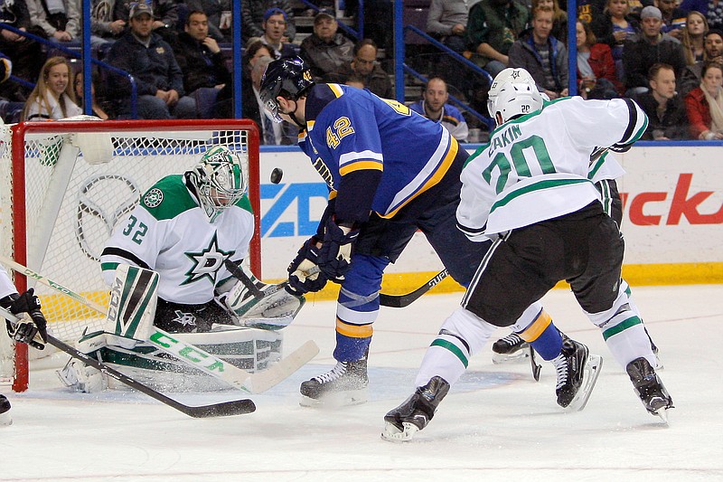 The puck is deflected by Dallas Stars goalie Kari Lehtonen, of Finland, on a shot from St. Louis Blues' David Backes, center, during the second period of an NHL hockey game Saturday, Dec. 27, 2014, in St. Louis. 