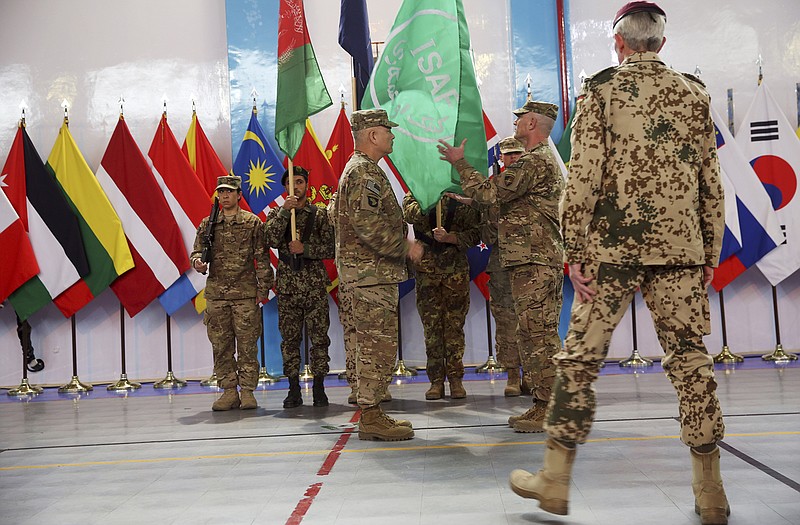 Commander of the International Security Assistance Force (ISAF), Gen. John Campbell, center, and Command Sgt. Maj. Delbert Byers, center right, case the ISAF flag during a Sunday ceremony as the United States and NATO formally ended their war in Afghanistan.