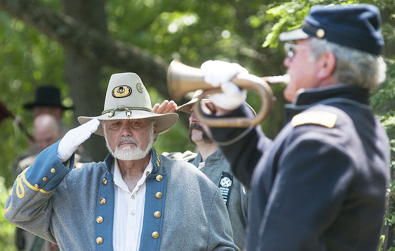 Commander Noel Crowson of Auxvasse salutes as bugler Paul Hobbs plays "Taps" in July at the Moore's Mill Mass Grave dedication in Calwood. Crowson was one of the researchers who teamed up to discover who died at the Battle at Moore's Mill during the Civil War.