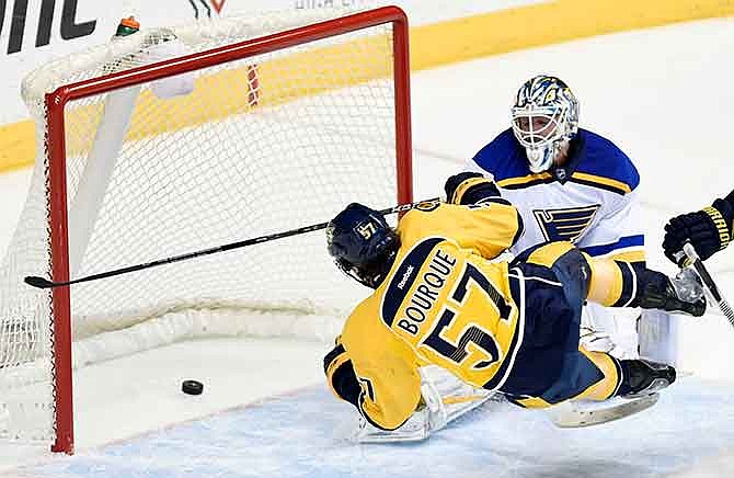 Nashville Predators left wing Gabriel Bourque (57) goes airborne as he shoots against St. Louis Blues goalie Brian Elliott in the second period of an NHL hockey game Tuesday, Dec. 30, 2014, in Nashville, Tenn.