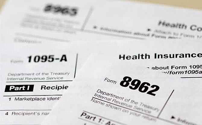 In this photo taken Aug. 21, 2014, health care tax forms 8962, 1095-A, and 8965, are seen in Washington. Being uninsured in America will cost you more in 2015. In 2015, all taxpayers have to report to the Internal Revenue Service for the first time whether or not they had health insurance the previous year. Most will check a box. It's also when the IRS starts collecting fines from some uninsured people, and deciding if others qualify for exemptions.
