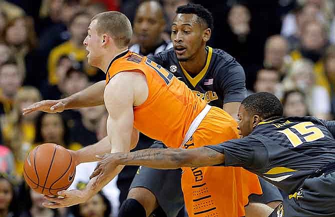 Missouri's Johnathan Williams III, back and Wes Clark (15) try to steal the ball from Oklahoma State's Phil Forte III (13) during the first half of an NCAA college basketball game Tuesday, Dec. 30, 2014, in Kansas City, Mo. 