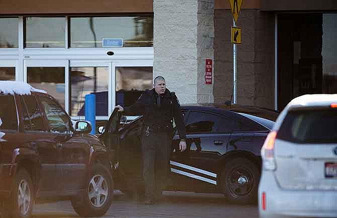 An Idaho State Patrol officer arrives at Wal-Mart in Hayden, Idaho, Tuesday, Dec. 30, 2014. A 2-year-old boy accidentally shot and killed his mother after he reached into her purse at the northern Idaho Wal-Mart and her concealed gun fired, authorities said Tuesday. (AP Photo/Coeur d'Alene Press, Tess Freeman) 