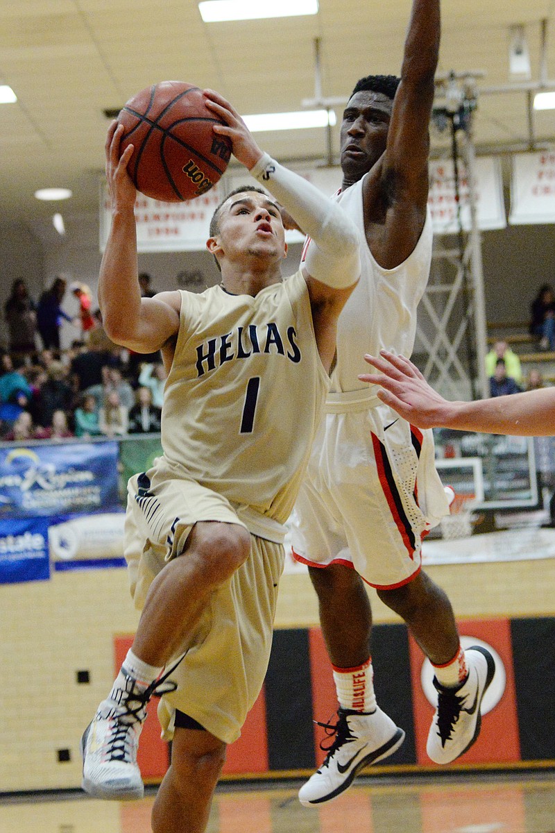 Isiah Sykes of Helias breaks past Tulsa Union defenders for a basket during Monday night's championship game in the Joe Machens Great 8 Classic at Fleming Fieldhouse. Sykes, selected as the tournament's Most Valuable Player, and Helias defeated Tulsa Union 43-41 for the title.